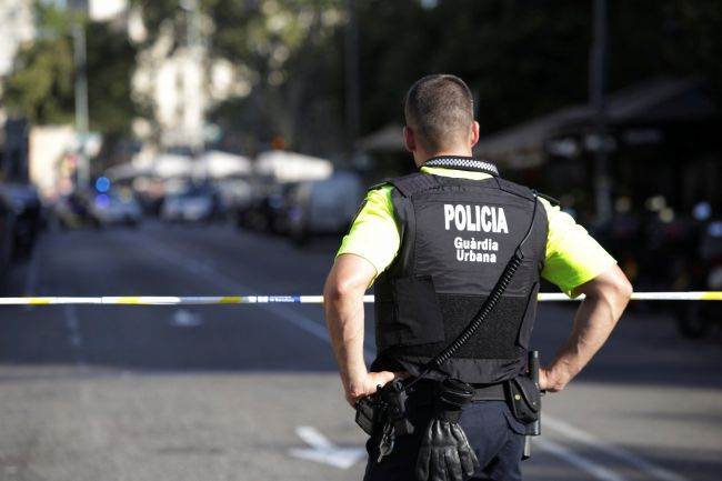 A police officer stands by a cordoned off street after a van crashed into pedestrians near the Las Ramblas avenue in central Barcelona
